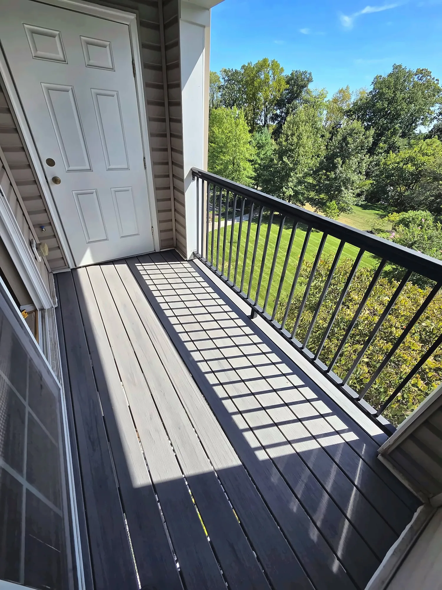 Second-floor balcony with new composite decking and metal railings