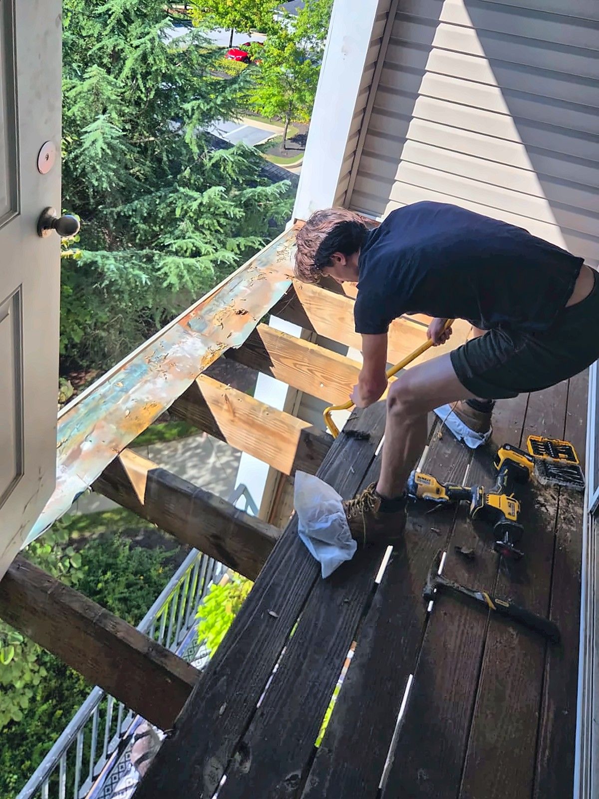 Crew member removing old boards from a balcony deck