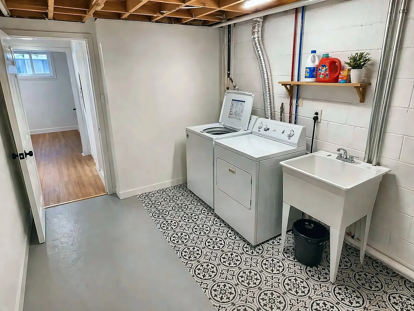 Basement laundry room with patterned tile floor