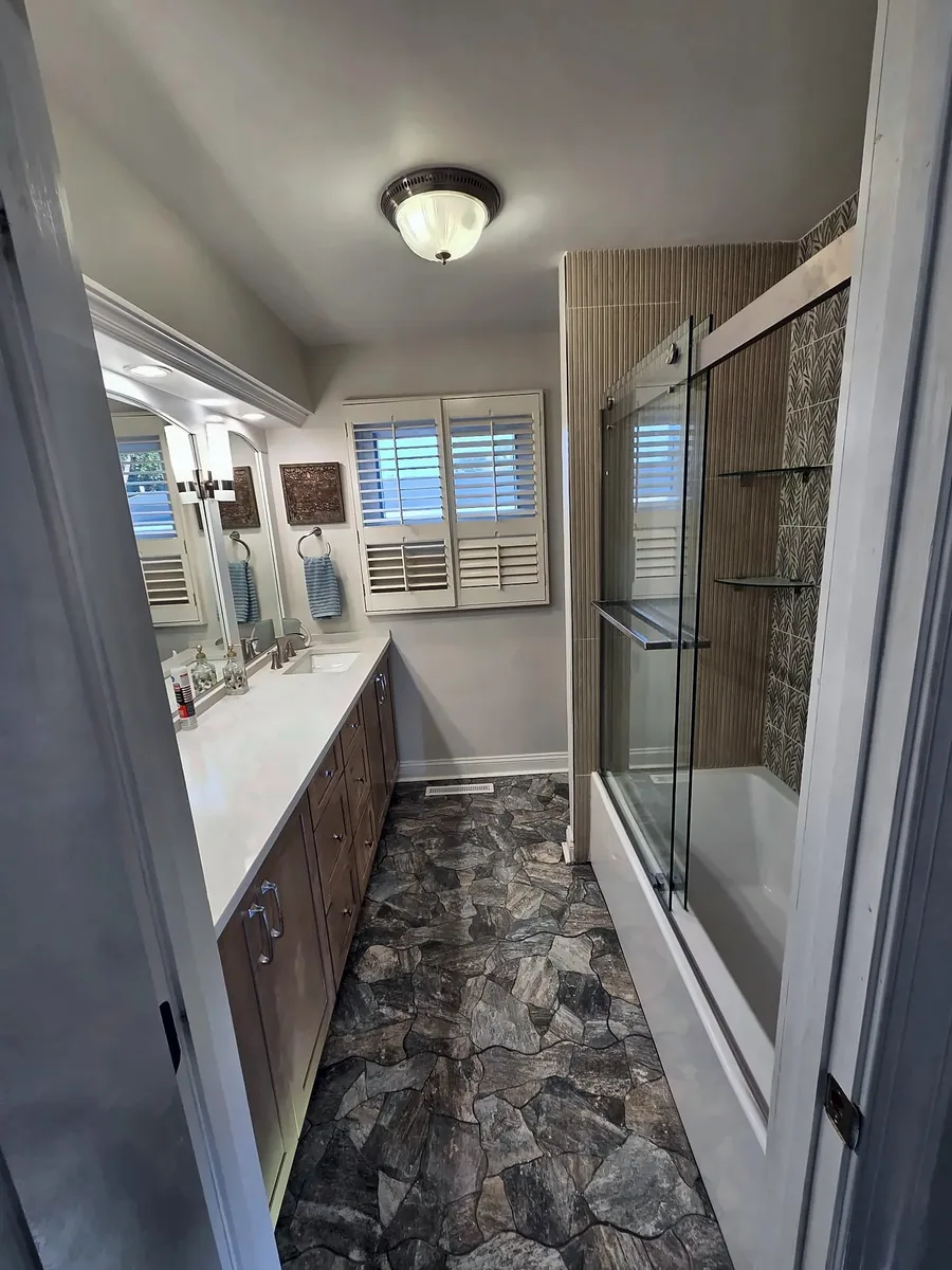 After: Wide view of a remodeled bathroom with stone-look floor