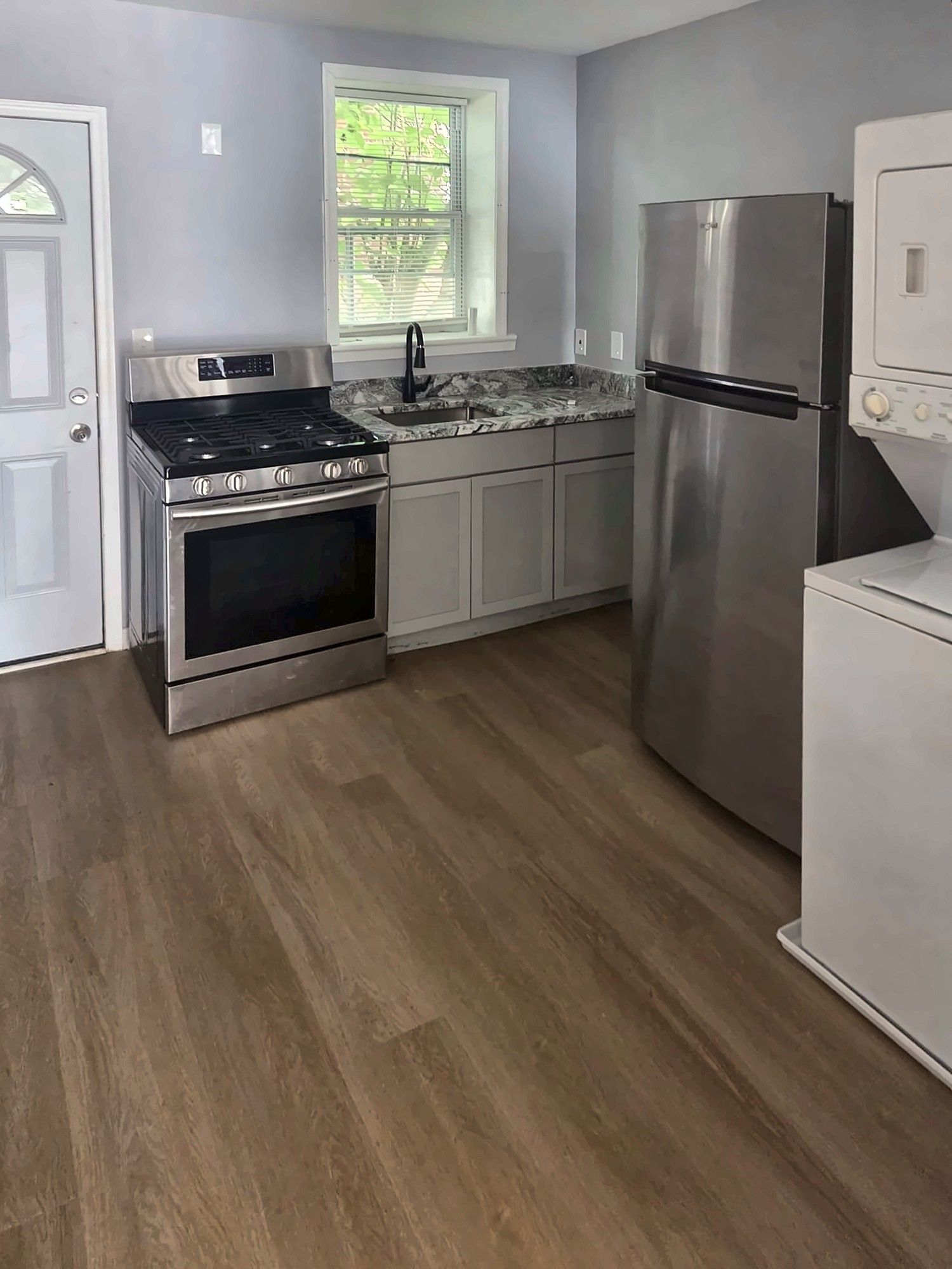Compact remodeled kitchen with gray cabinets and stainless appliances