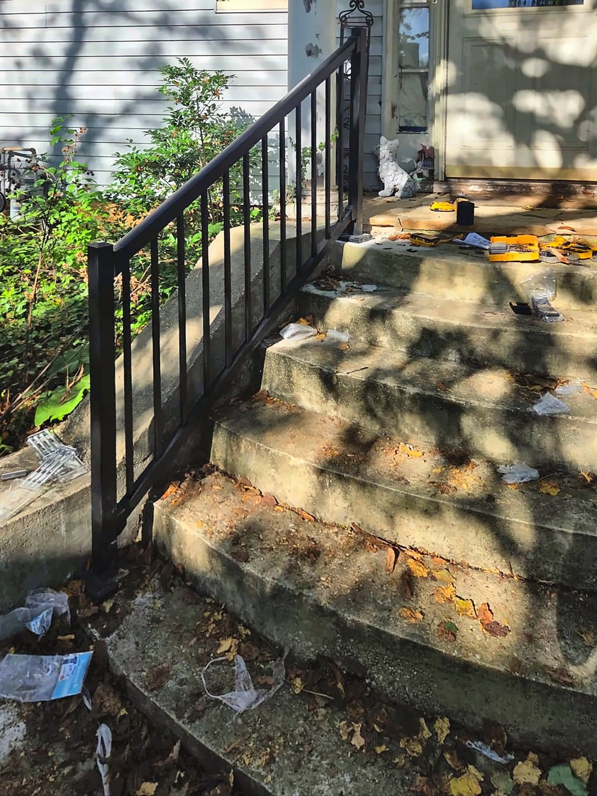 New black metal railing installed on concrete front steps