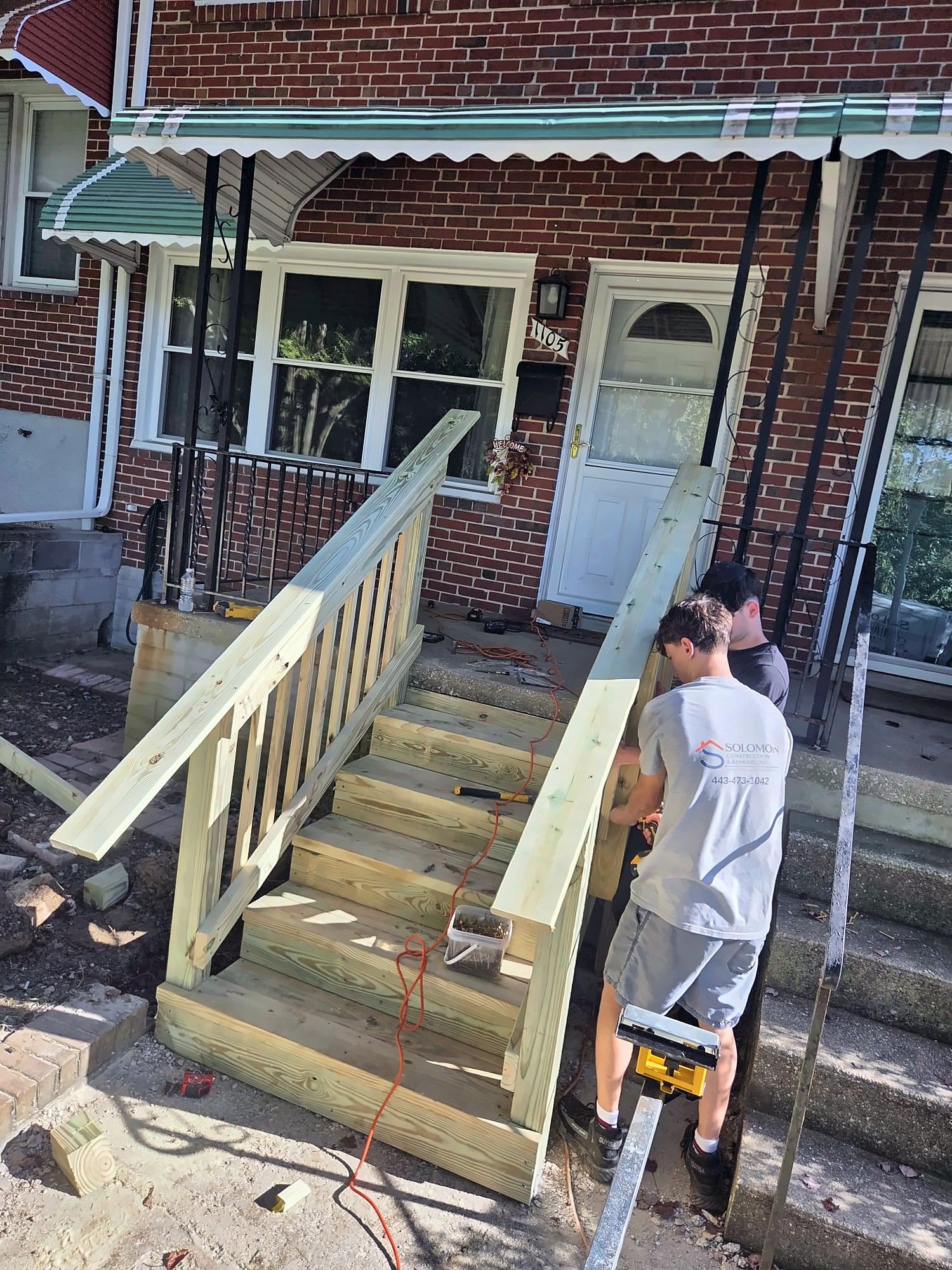 Solomon crew building wood railings on front entry steps