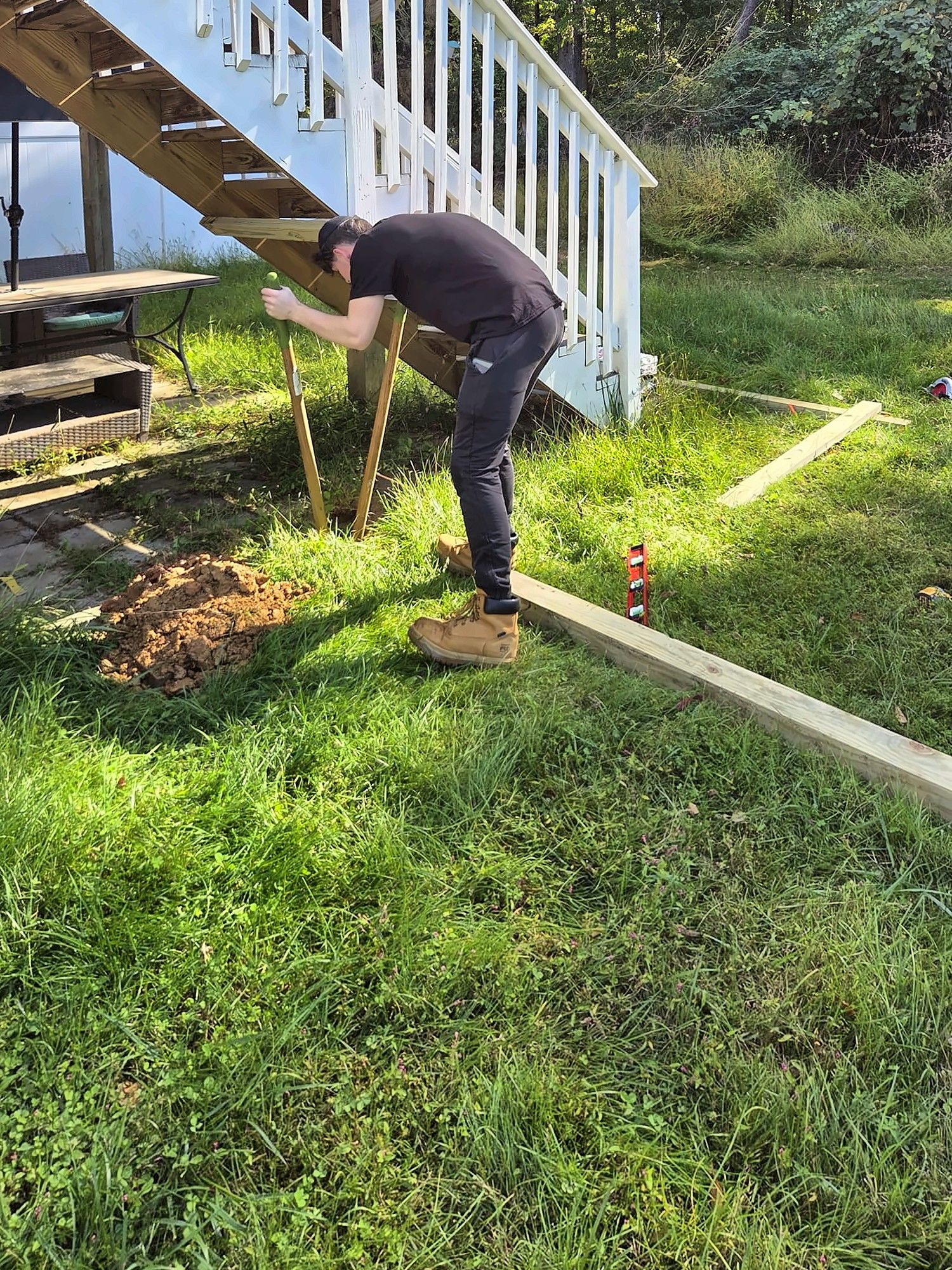 Carpenter setting posts for rear deck stairs