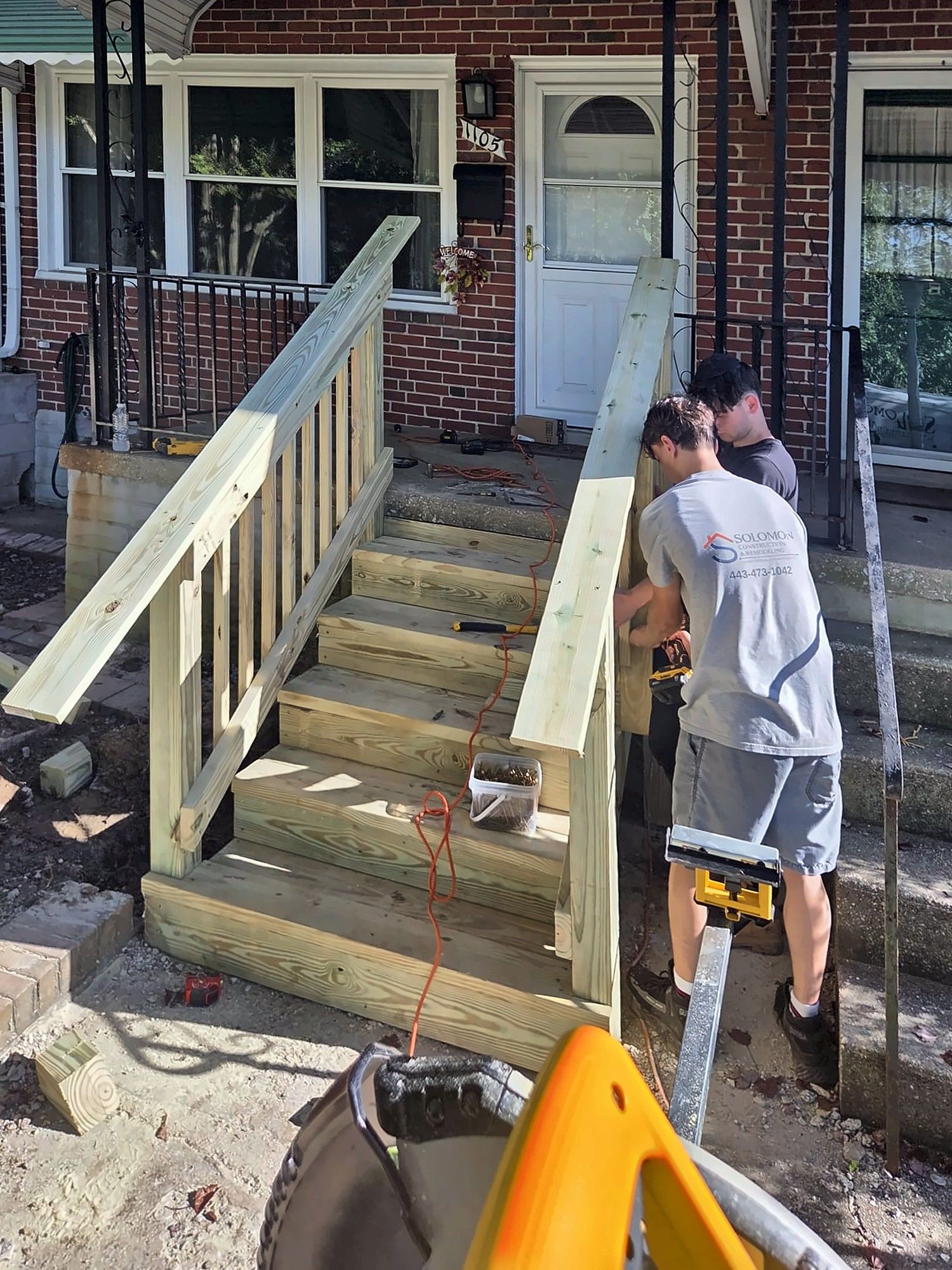 Carpenter installing a stair railing on new front steps