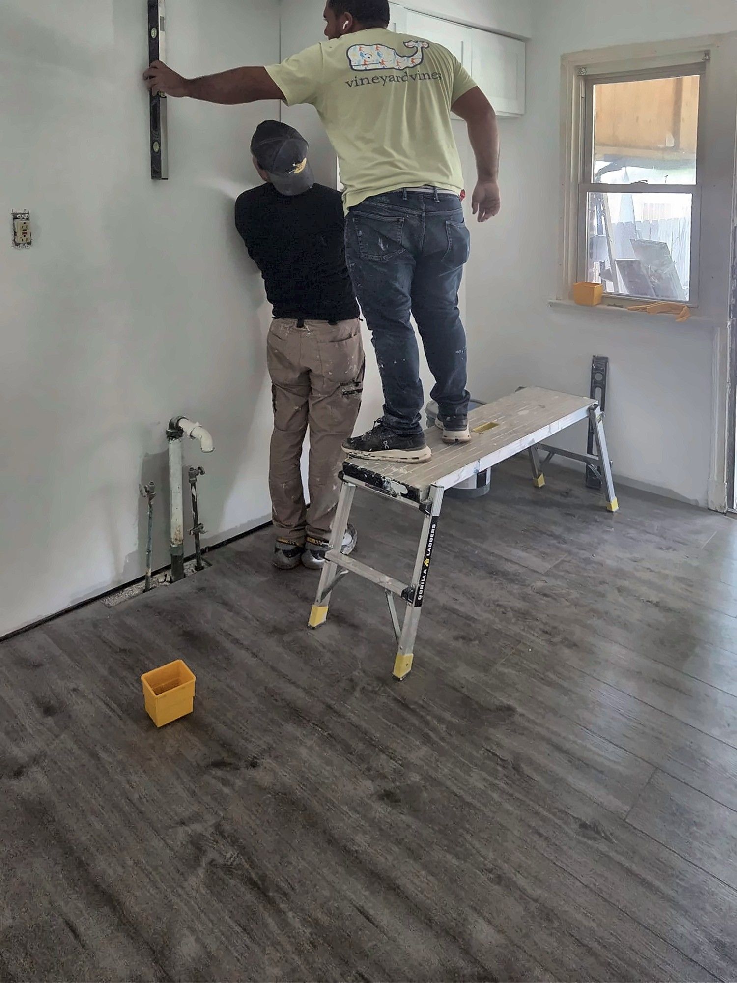 Crew leveling a wall for kitchen cabinet installation