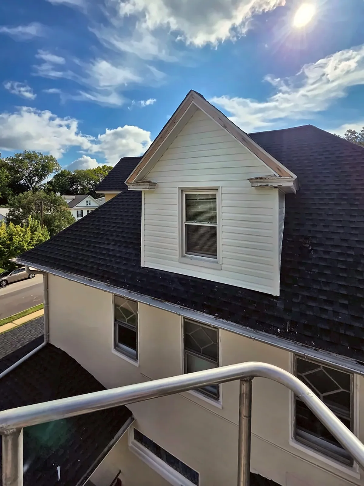 White vinyl-sided dormer on a dark shingle roof