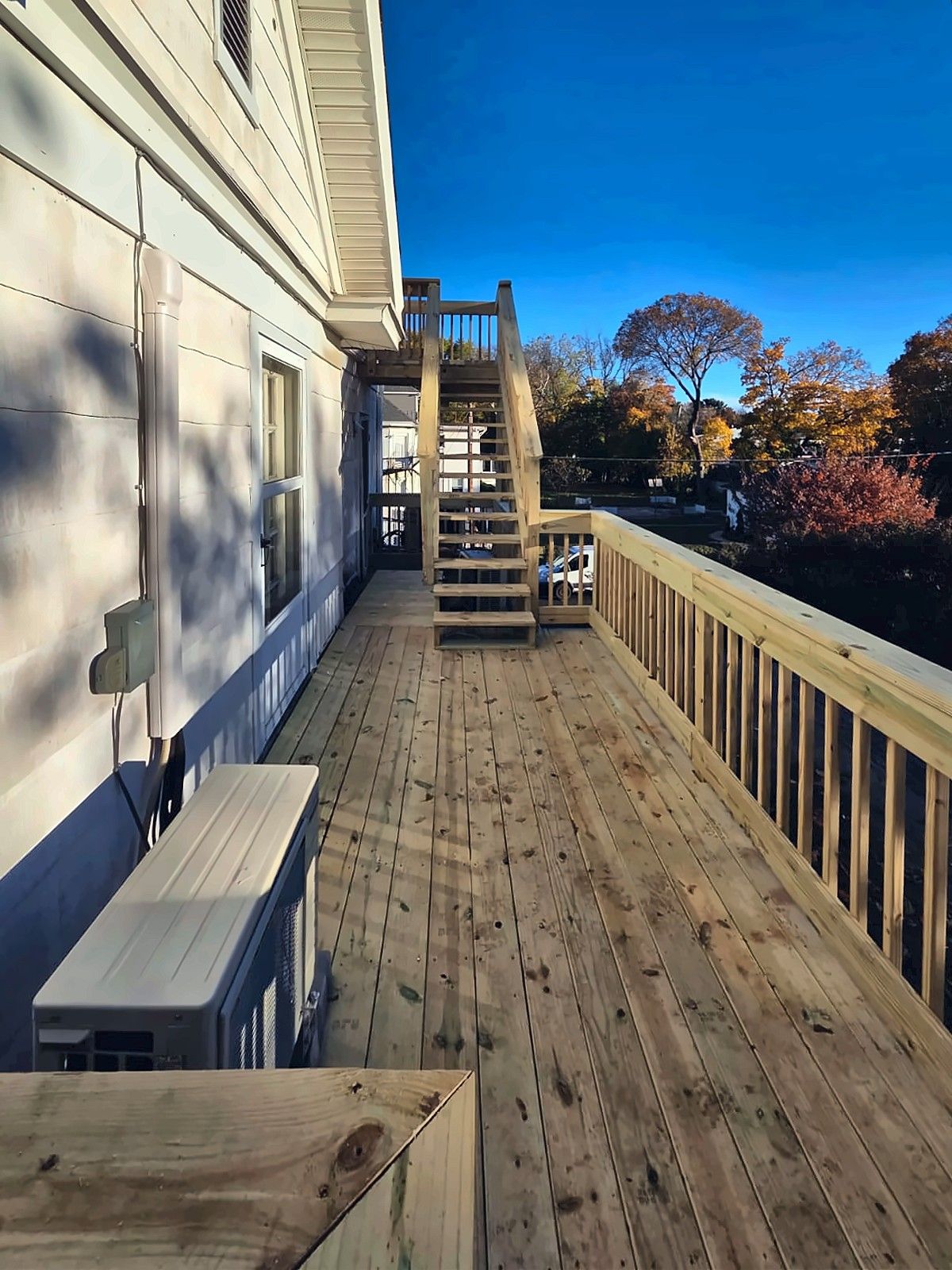 Elevated wood deck walkway along the side of a house