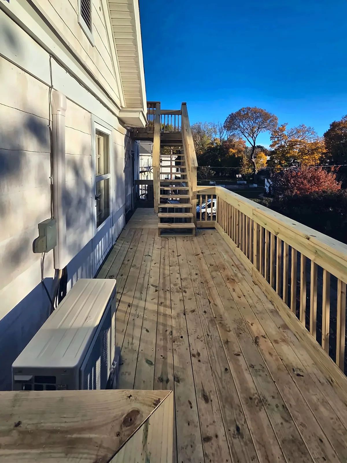Elevated wood deck walkway along the side of a house