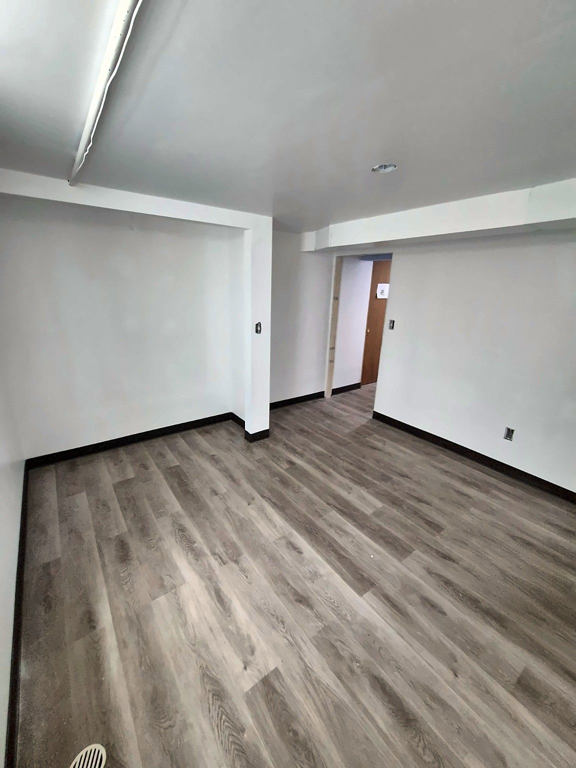 Finished basement with gray flooring, alternate angle