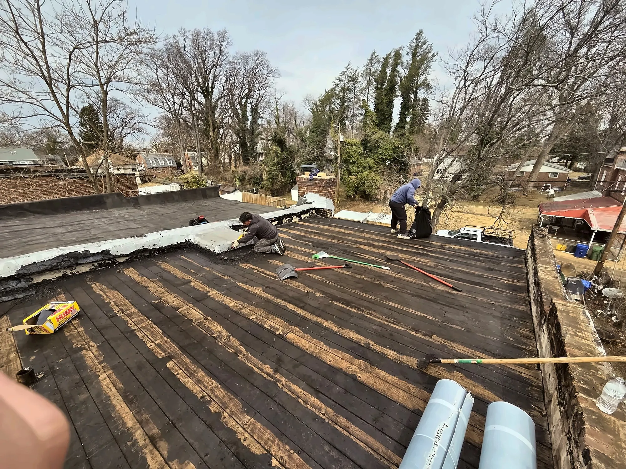 Roofing crew tearing off an old flat roof