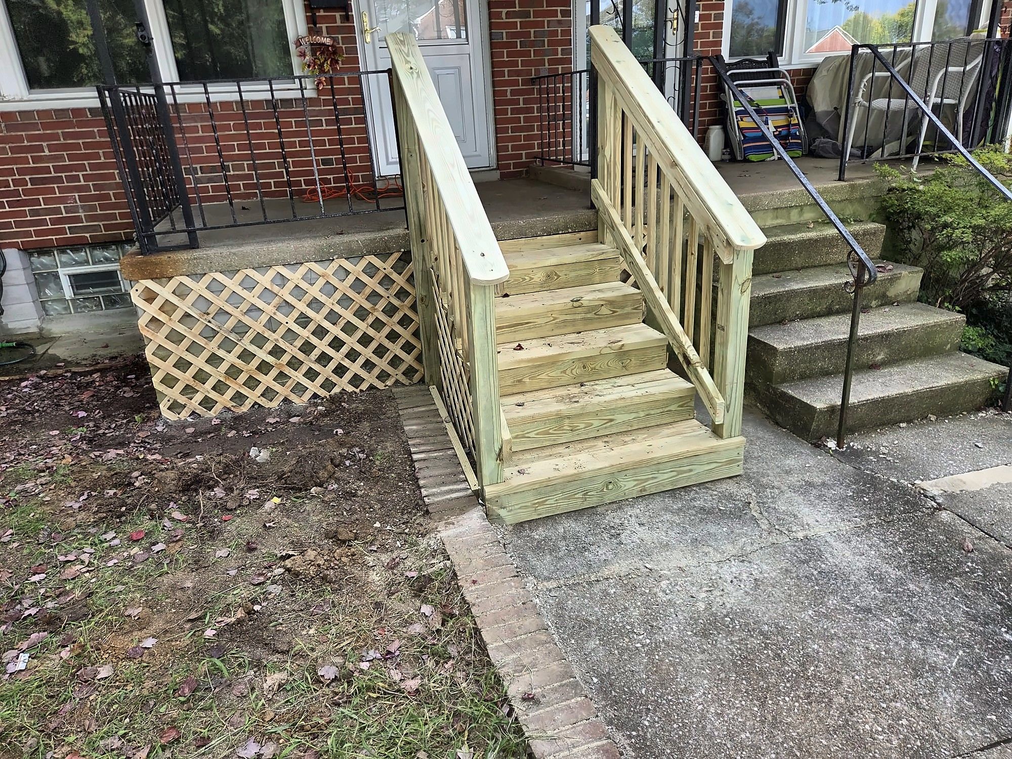 Side view of new wood front steps with lattice skirting