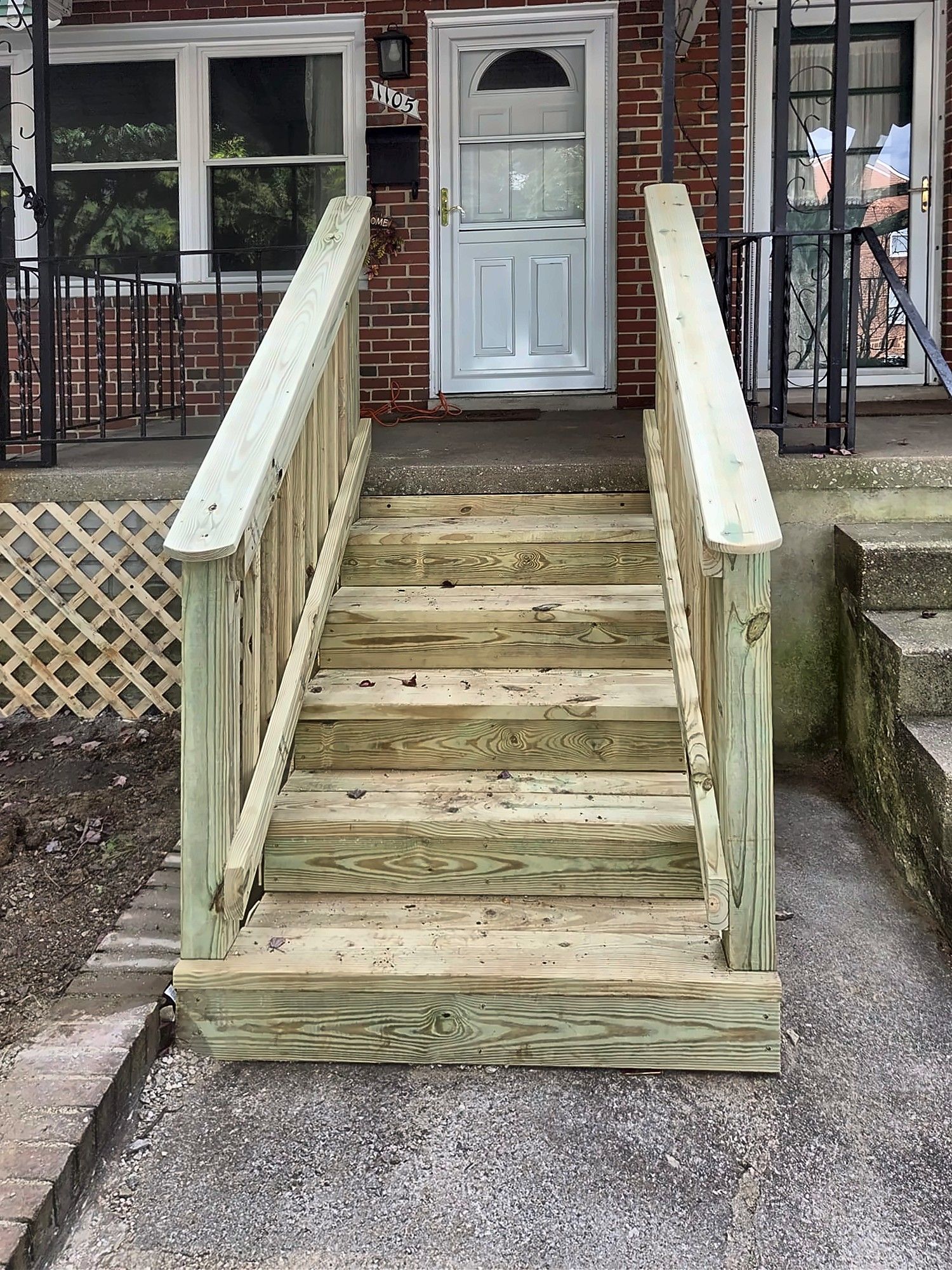 Finished wood front entry steps with handrails