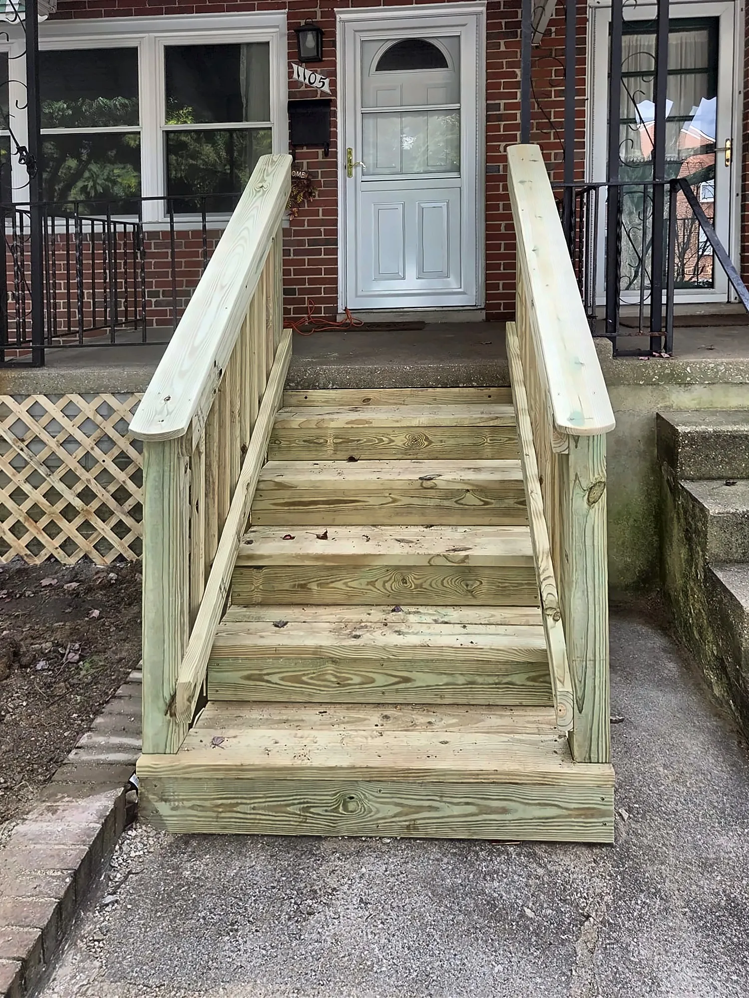 Finished wood front entry steps with handrails