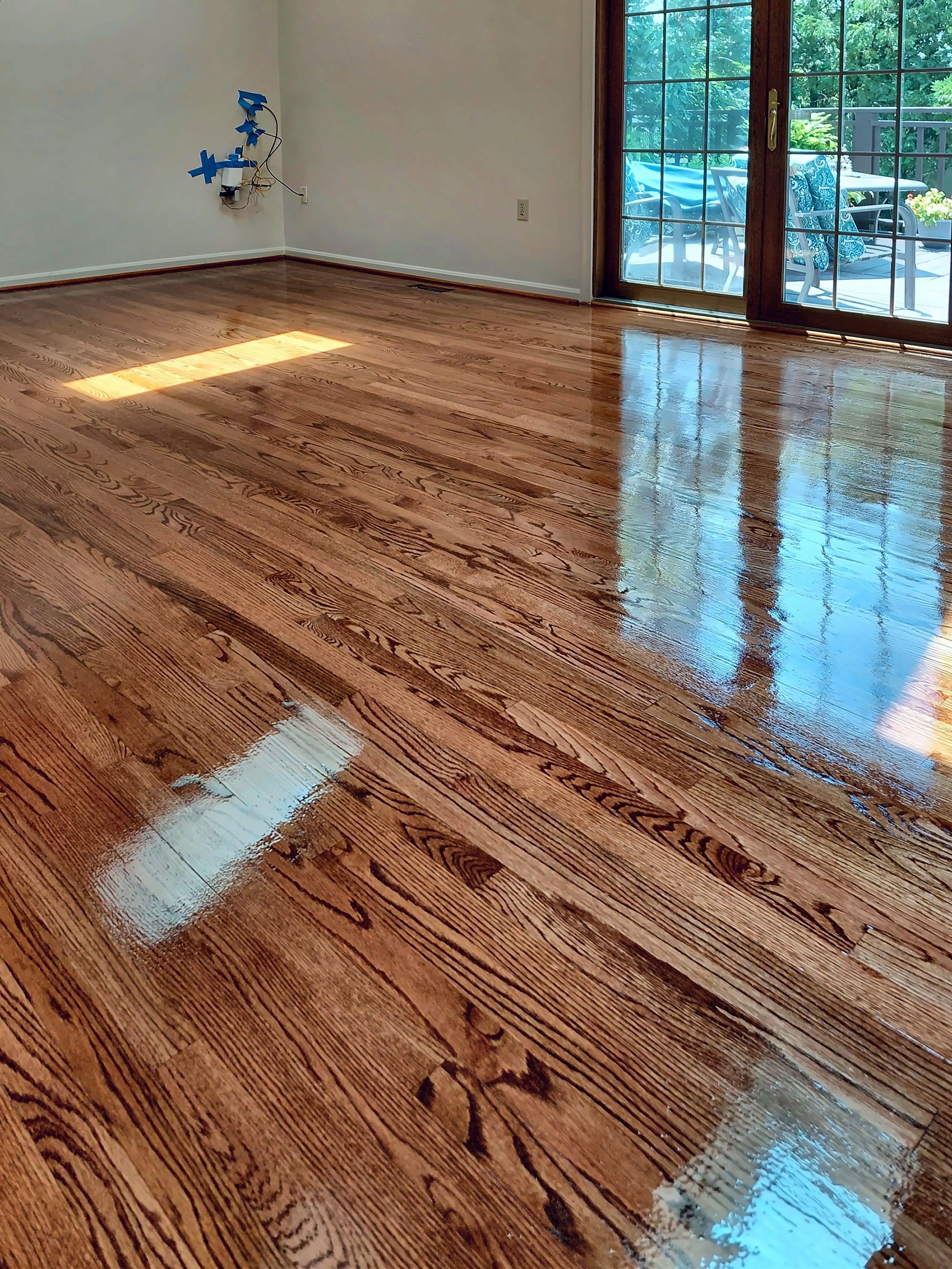 Refinished high-gloss hardwood floor in an empty room