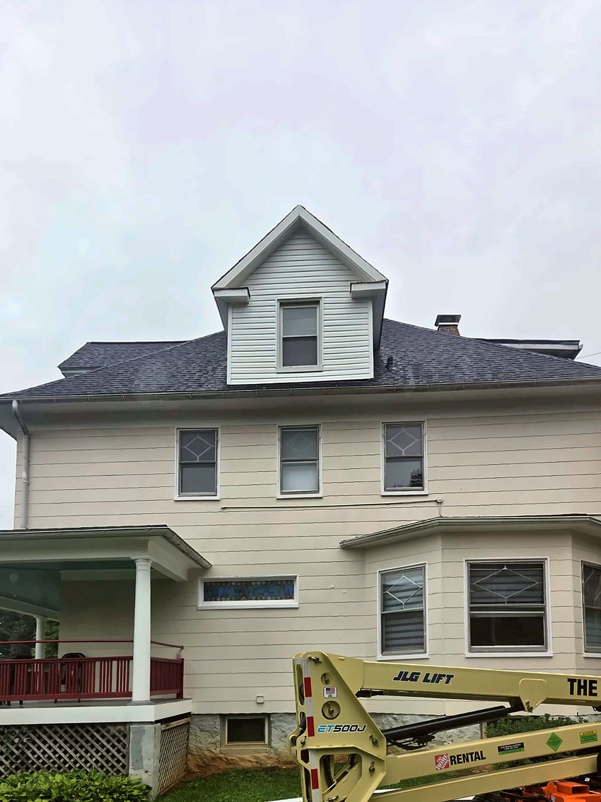 Boom lift at a two-story house during exterior work