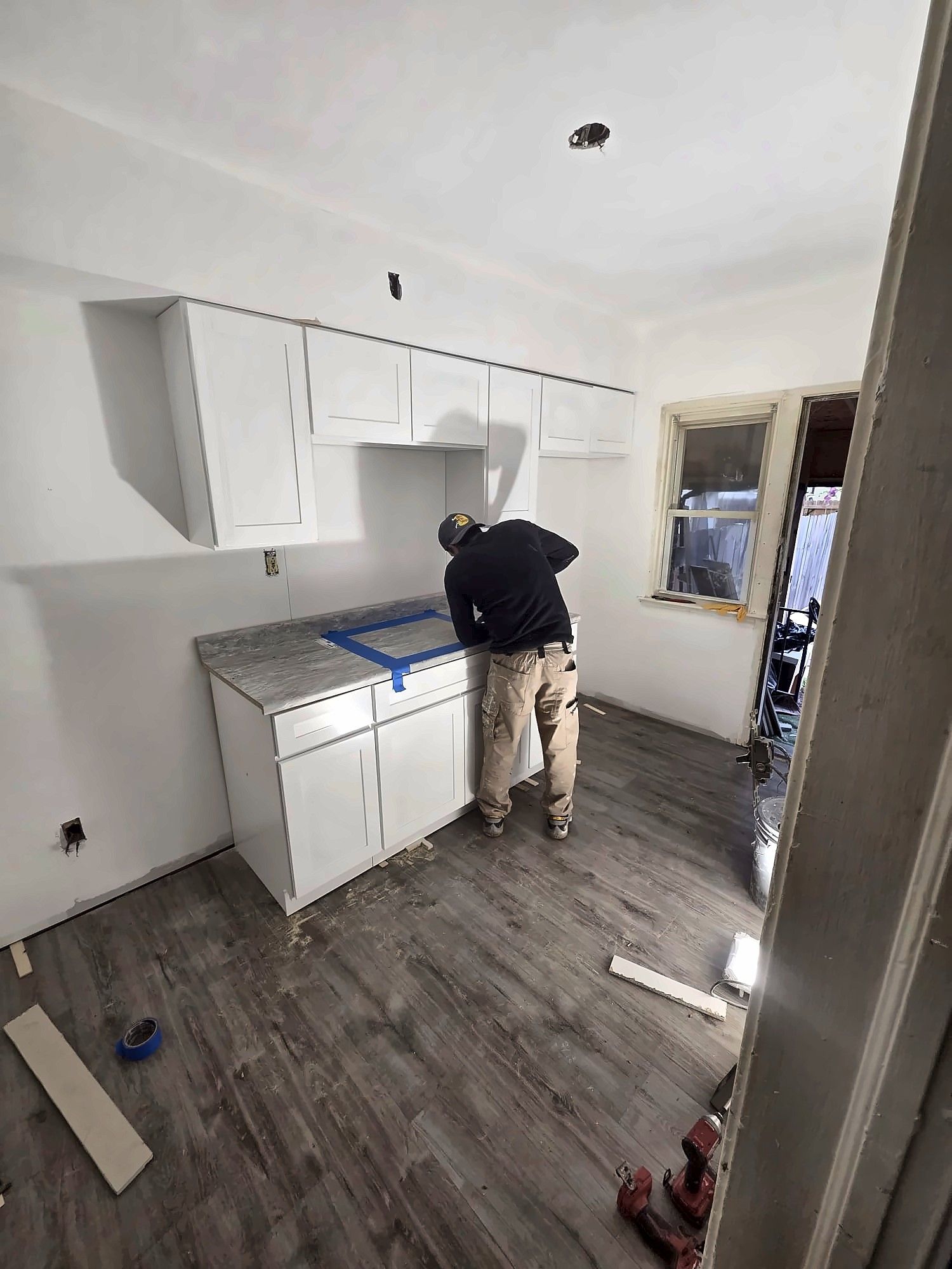 Installer setting kitchen base cabinets and countertop