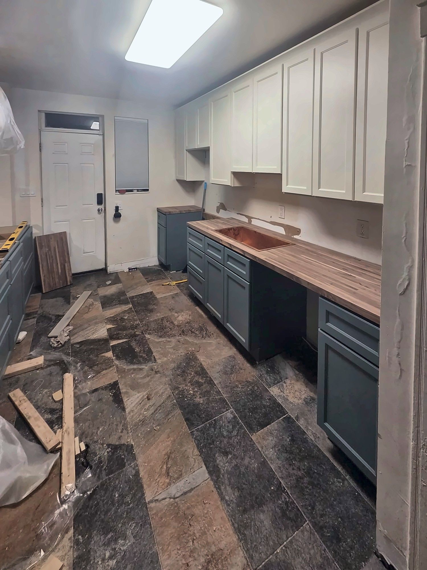 Two-tone kitchen being installed with butcher-block counter