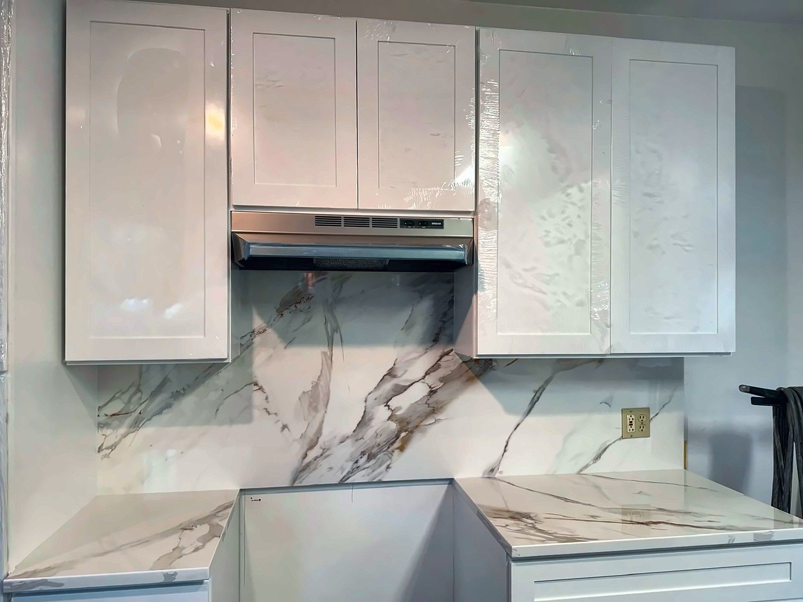 Marble-look slab backsplash with white gloss cabinets