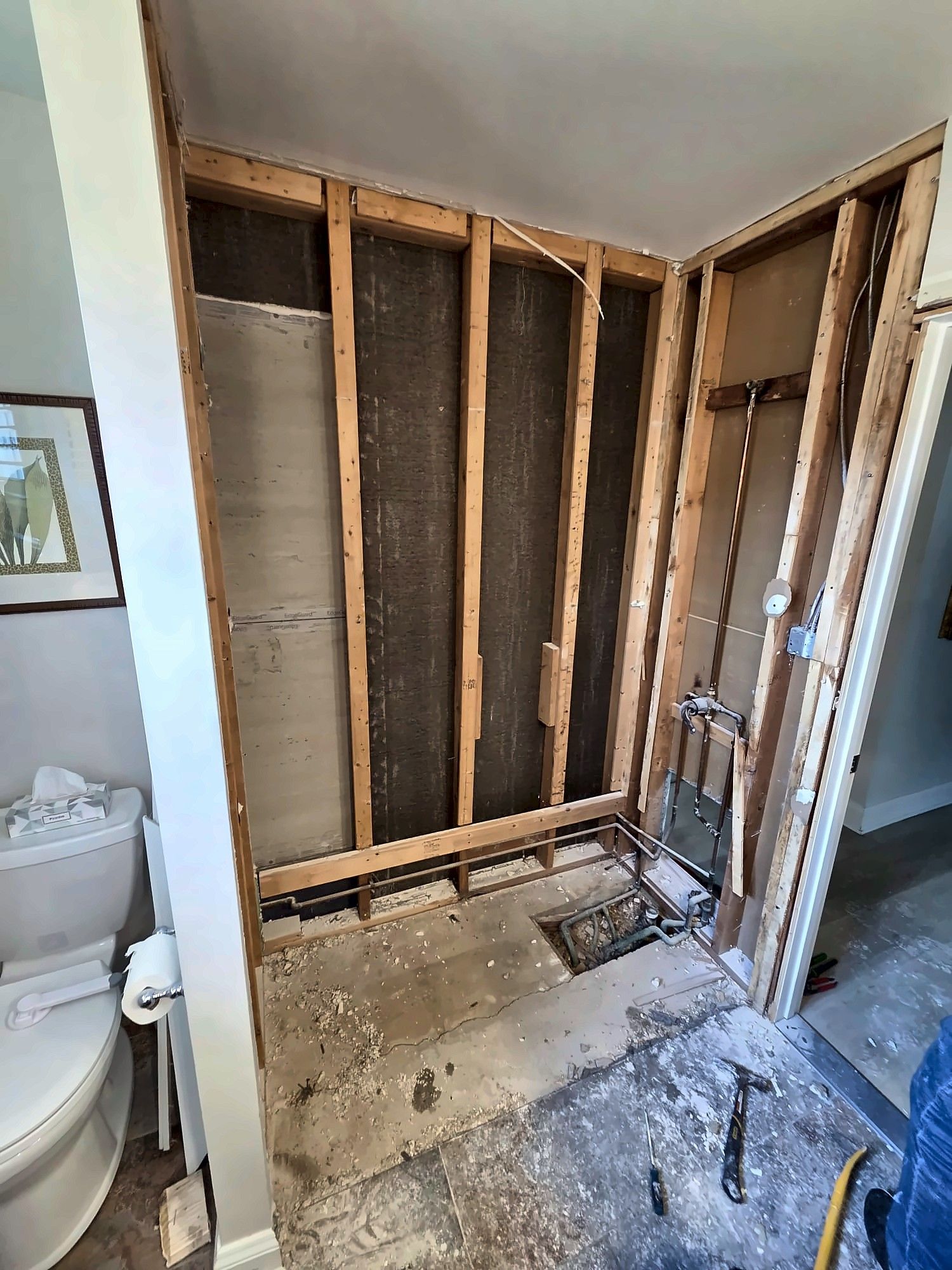 Wide view of a bathroom gutted to the studs