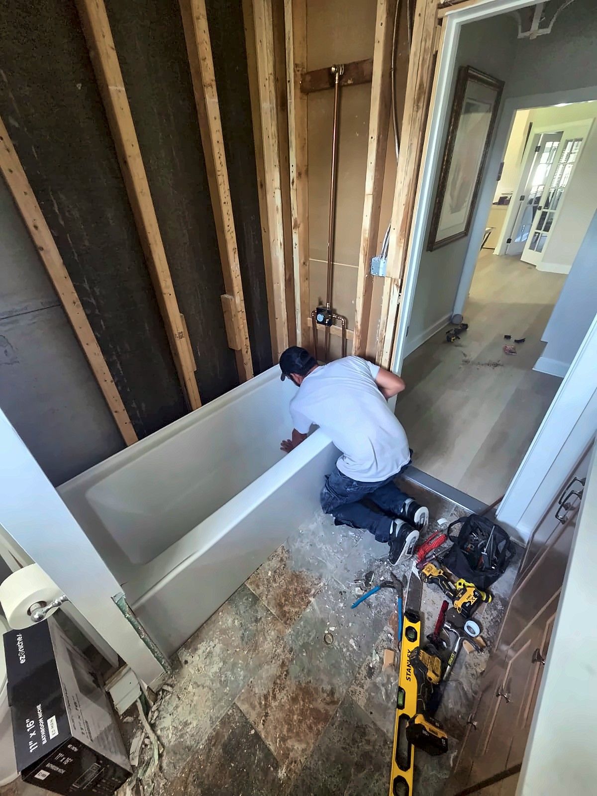 Crew member installing a new tub in a gutted bathroom
