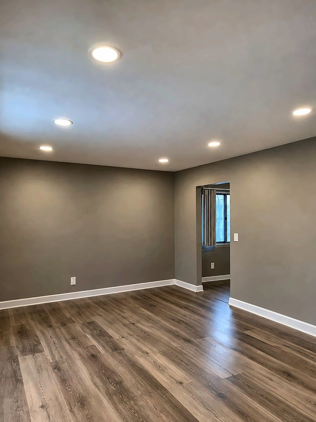 Renovated living room with wood-look vinyl plank floor and recessed lighting