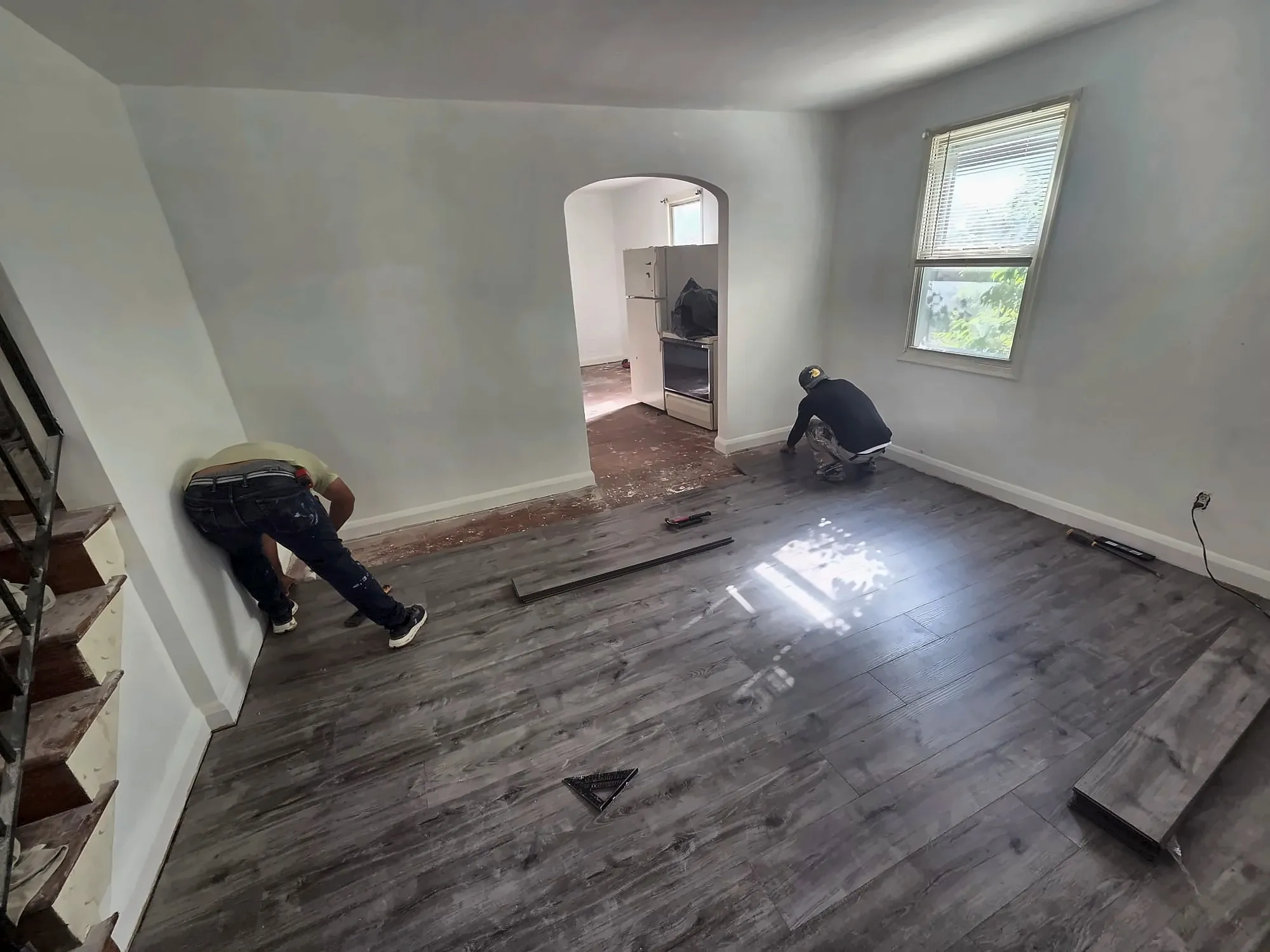 Gray wood-look vinyl plank flooring being installed