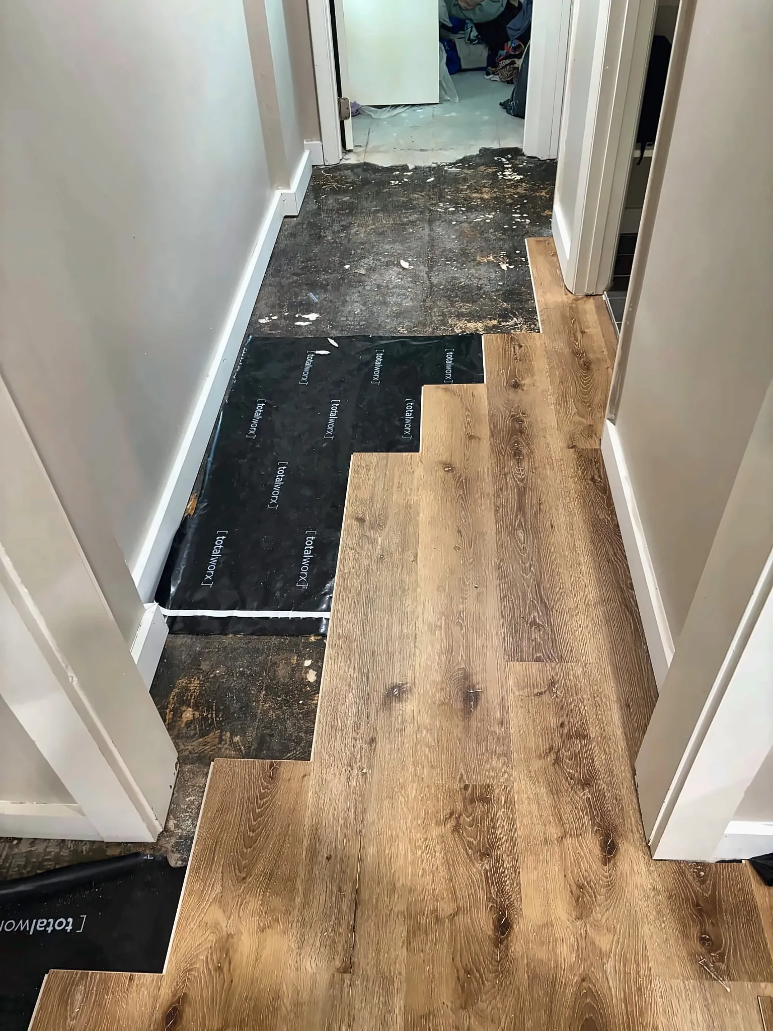 Vinyl plank flooring being installed in a hallway