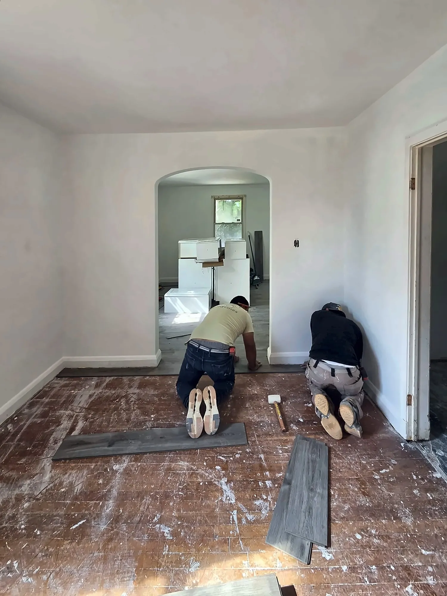 Two installers laying vinyl plank flooring