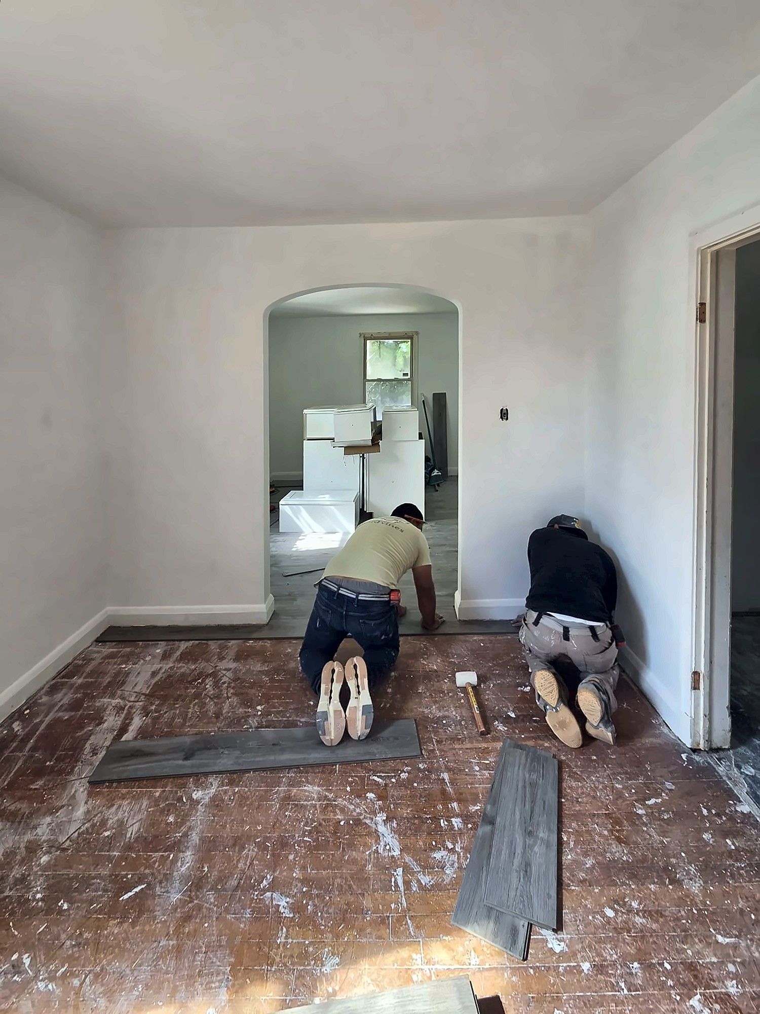 Two installers laying vinyl plank flooring