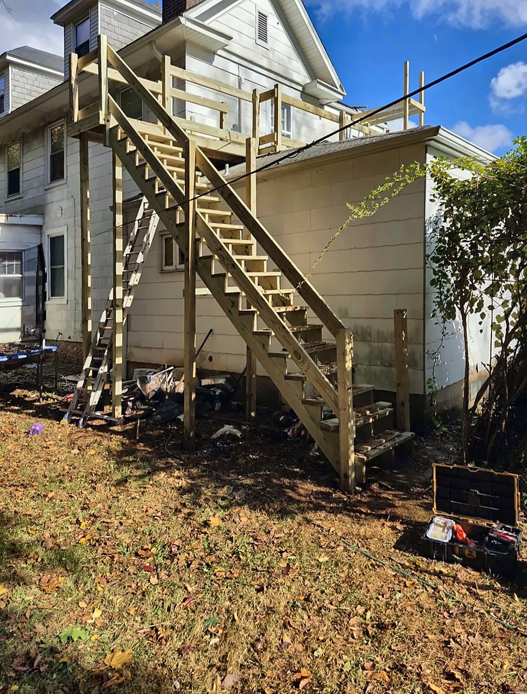 Tall exterior wood staircase being built on a multi-story house