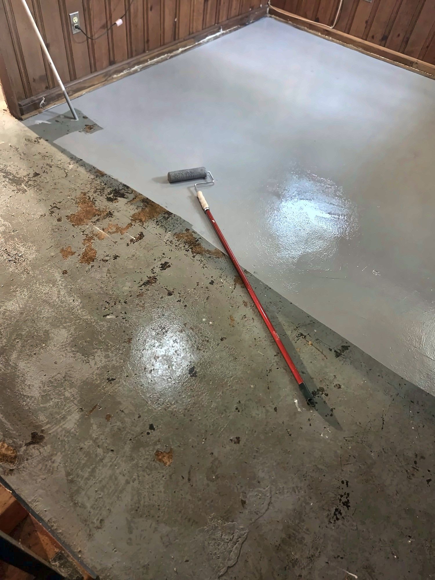 Concrete basement floor being painted gray