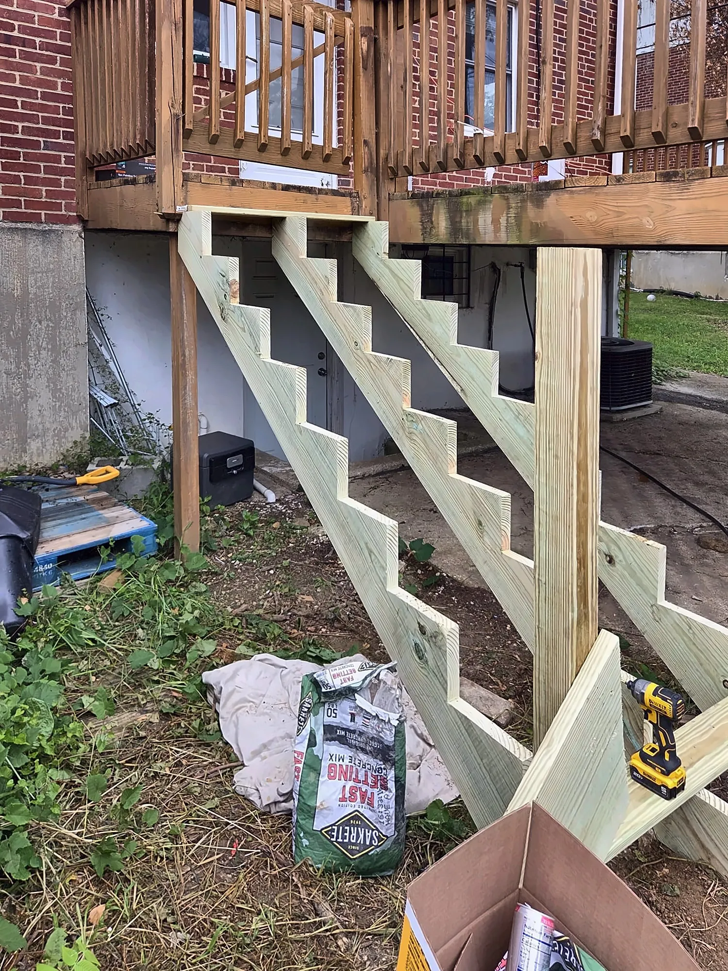 New wood stair stringers from a rear deck on a brick house