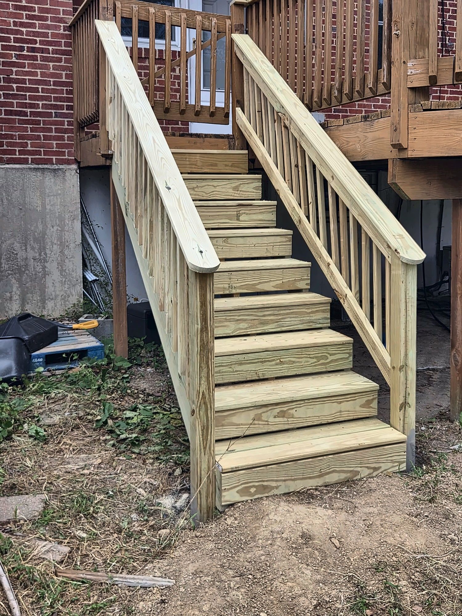 New pressure-treated wood stairs leading to a rear deck