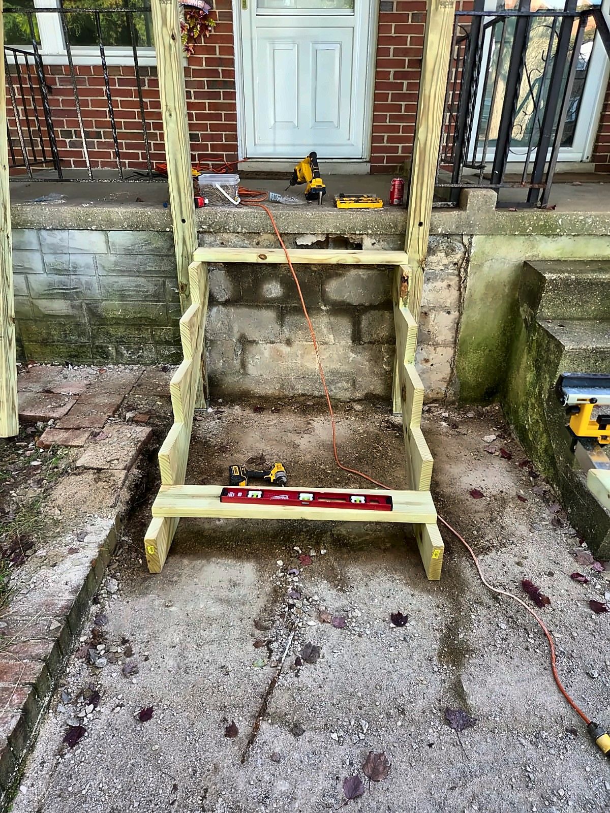 New stair frame against a block foundation at a rowhouse entry