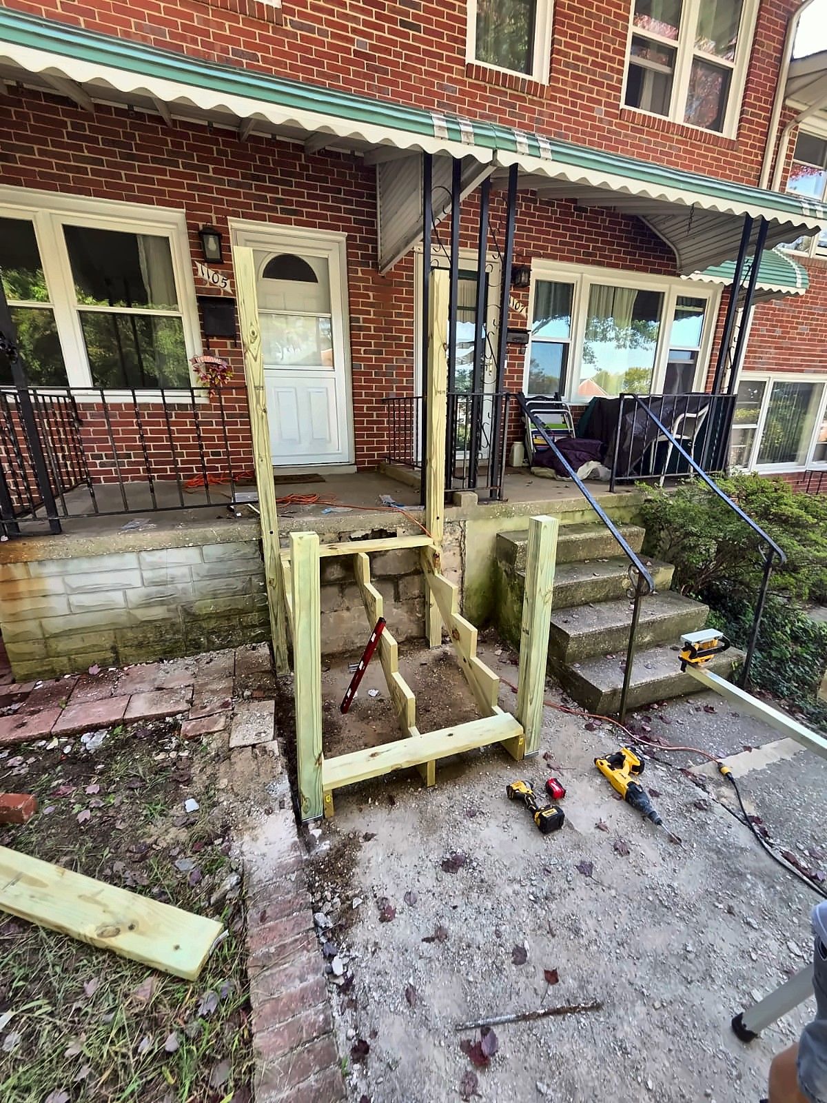 New wood stair framing at a brick rowhouse front entry