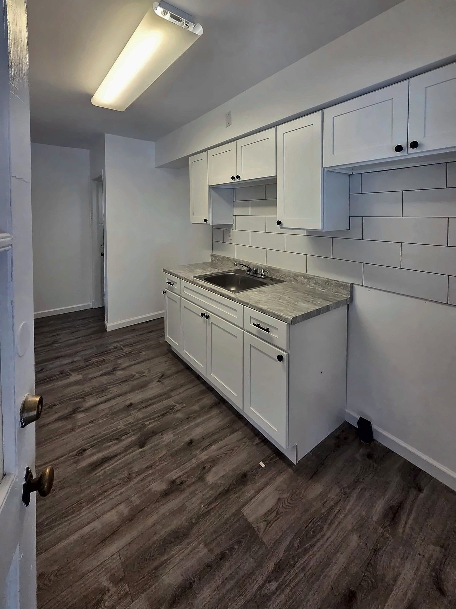 Galley view of a small white kitchen
