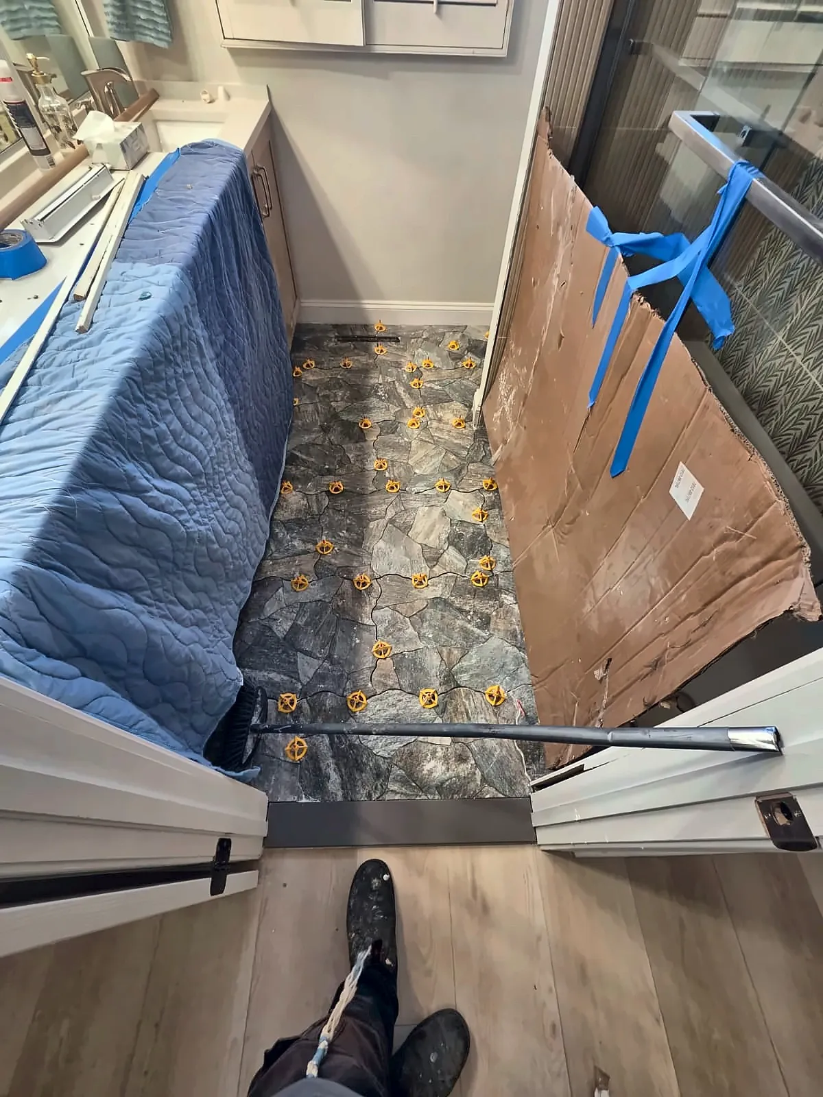 Stone-look floor tile being installed with leveling clips