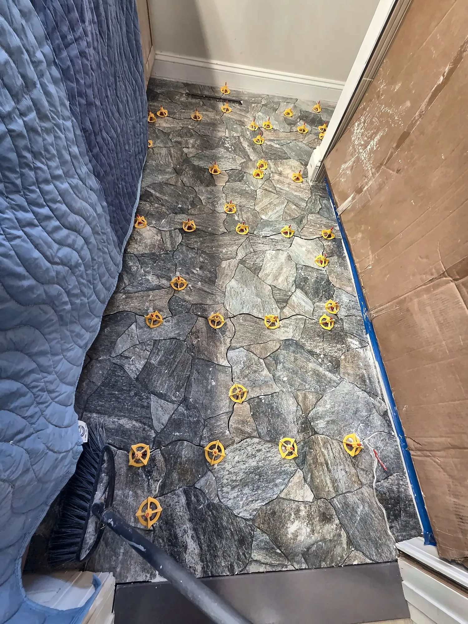 Close-up of stone-look floor tile with leveling clips