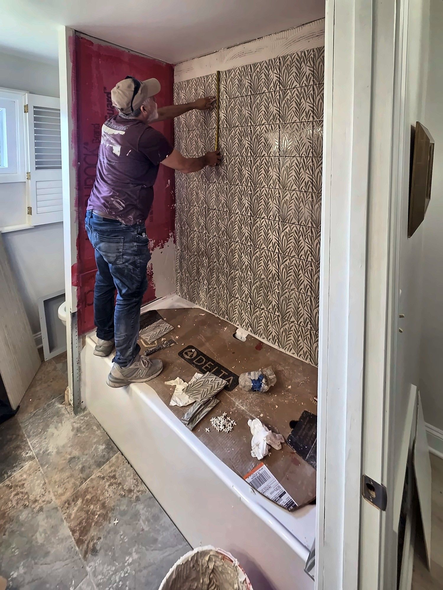Tile setter installing bathtub wall tile
