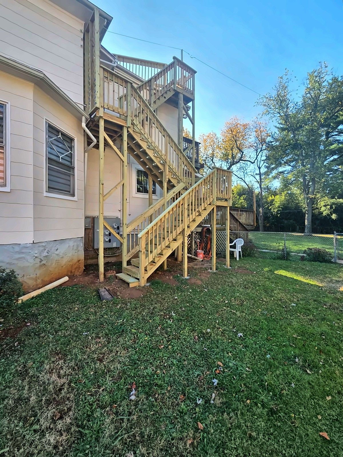Two-story exterior wood staircase on the side of a home